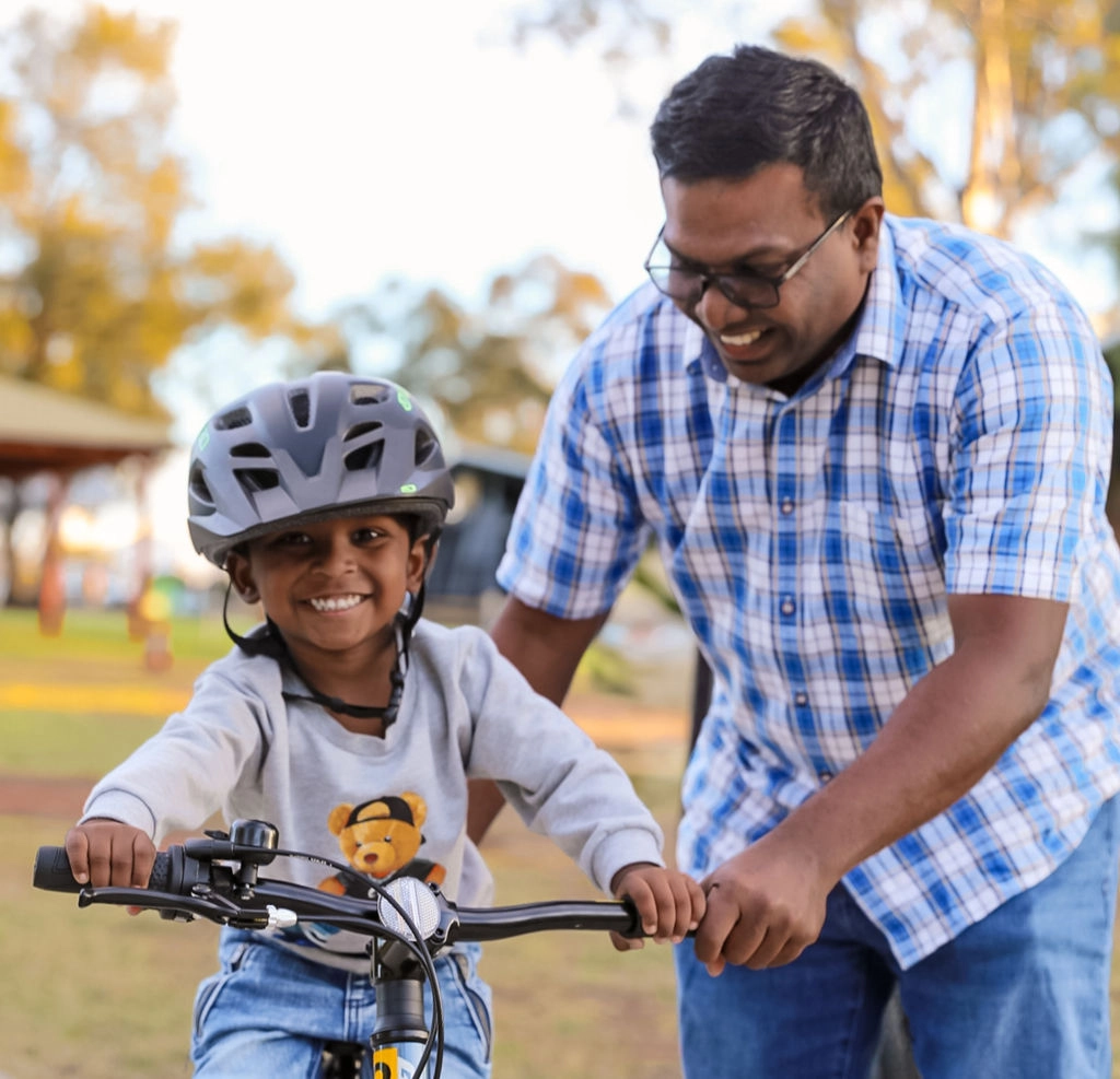 Father and son riding bikes in park